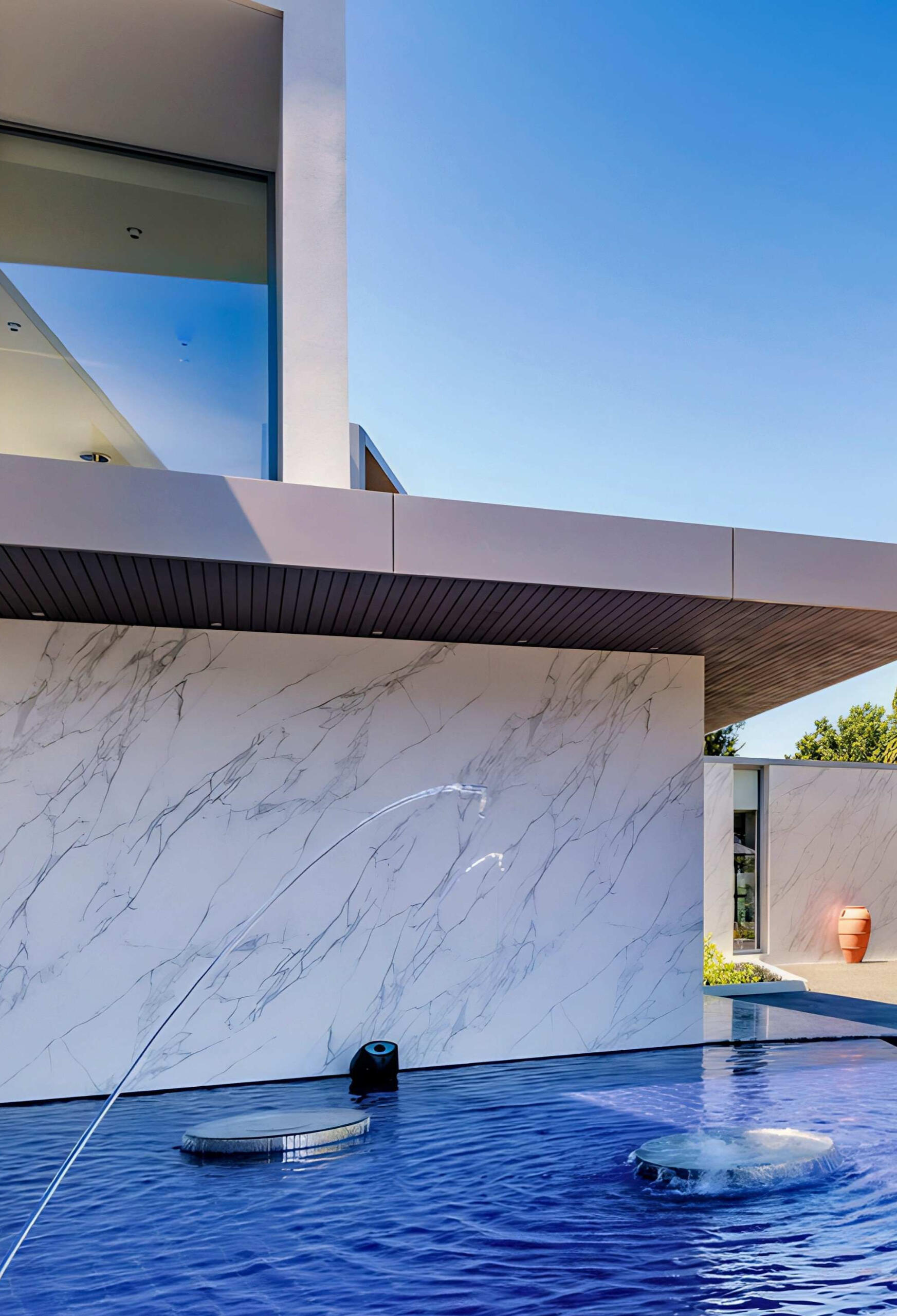 Modern Luxury Home with Stone Exterior Water Feature in Ontario Elegant modern home exterior with stone feature wall, reflective water feature, and sleek architectural design in Ontario, Canada.