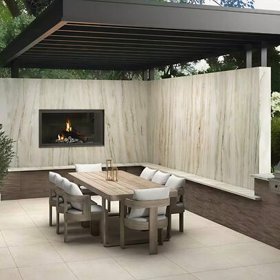 Luxury Outdoor Dining Area with Stone Fireplace in Ontario, Canada Elegant outdoor dining space with a built-in stone fireplace, bookmatch stone retaining wall, wooden dining table, and modern pergola surrounded by lush greenery in Ontario.